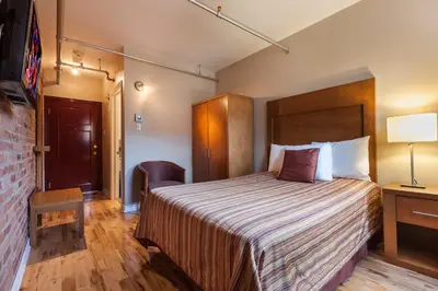 a hotel room with a bed and a lamp at Hotel Quartier des Spectacles in Montréal