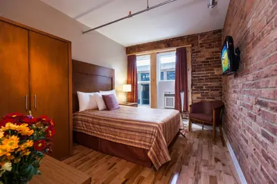 a hotel room with a bed and a brick wall at Hotel Quartier des Spectacles in Montréal