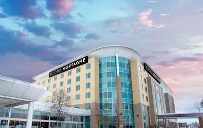 a building with a sign on top of it at Hotel Mortagne in Boucherville
