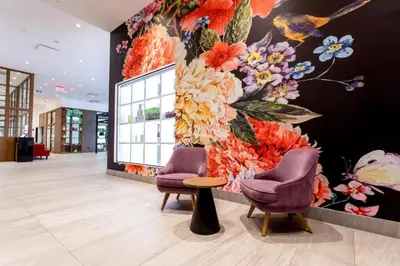 a lobby with two chairs and a flower wall at Hotel Mortagne in Boucherville