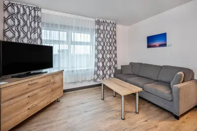 a living room with a couch and a flat screen tv at Quality Suites in Drummondville