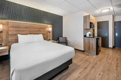 a hotel room with a bed and a desk at Quality Suites in Drummondville