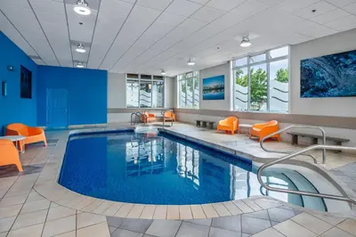 a pool in a hotel room with orange chairs and a pool at Quality Suites in Drummondville