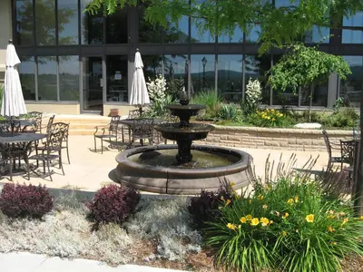 a fountain in front of a building with tables and chairs at Le President Sherbrooke in Sherbrooke
