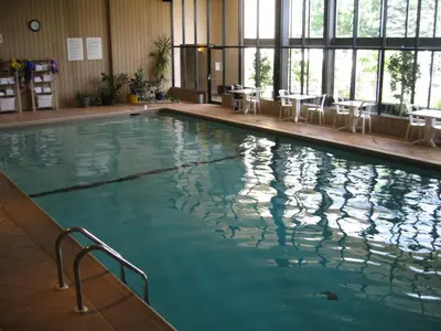 a large swimming pool with chairs in a building at Le President Sherbrooke in Sherbrooke