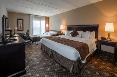 a hotel room with a large bed and a couch at Le President Sherbrooke in Sherbrooke