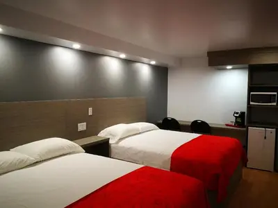a hotel room with two beds with red and white sheets at Motel Chez Nous in Laval