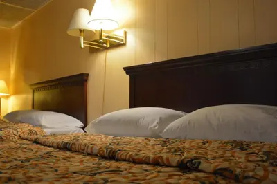 a bedroom with two beds with white pillows and a headboard at Motel Chez Nous in Laval