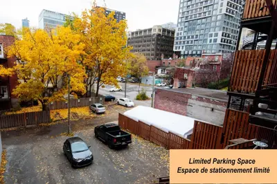a parking lot with cars parked in a city at Hotel Casa Bella in Montréal