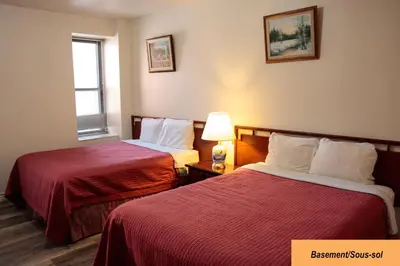 a hotel room with two beds with red sheets at Hotel Casa Bella in Montréal