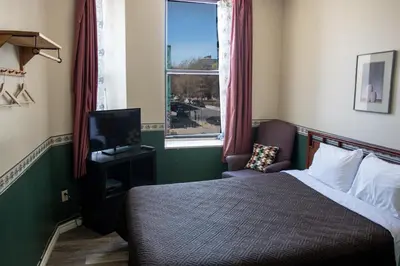 a bedroom with a bed and a tv and a window at Hotel Casa Bella in Montréal