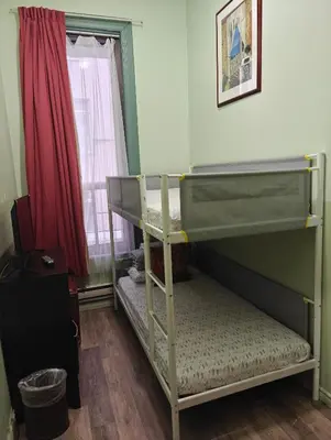 a bedroom with two bunk beds and a window at Hotel Casa Bella in Montréal