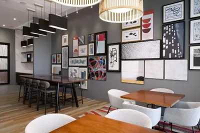 a dining room with tables and chairs and pictures on the wall at Residence Inn by Marriott Montreal Airport in Dorval