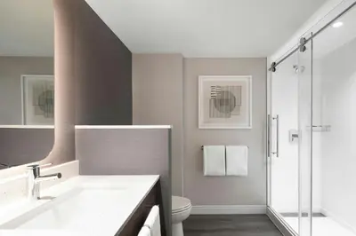 a bathroom with a sink and a toilet and a shower at Courtyard by Marriott Montreal Airport in Dorval
