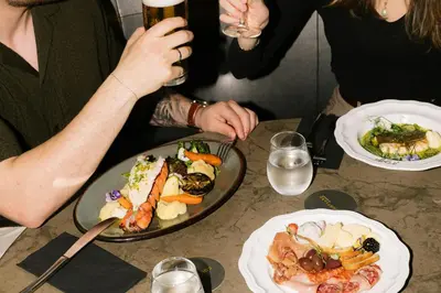 a group of people sitting at a table with plates of food at Courtyard by Marriott Montreal Airport in Dorval