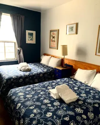 a hotel room with two beds and a window at Pensione Popolo in Montréal
