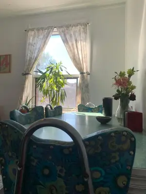 a dining room with a table and chairs and a window at Pensione Popolo in Montréal