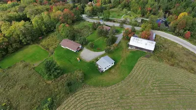 an aerial view of a farm with a house and a road at Auberge Schweizer in Sutton