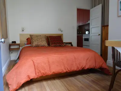 a bedroom with a bed with an orange blanket at Gite à Coté in Montréal