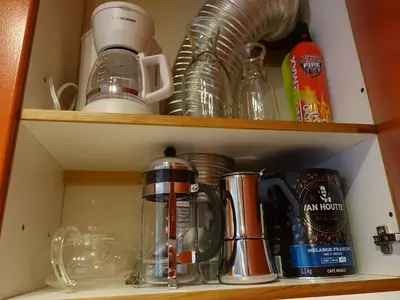 a cupboard filled with dishes and other kitchen items at Gite à Coté in Montréal