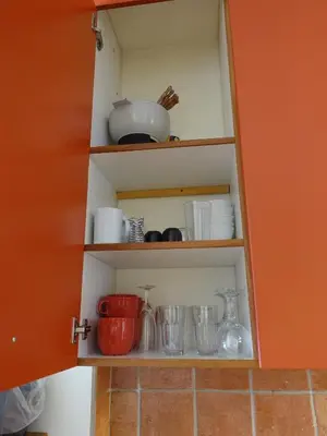 a cupboard with dishes and utensils in it at Gite à Coté in Montréal