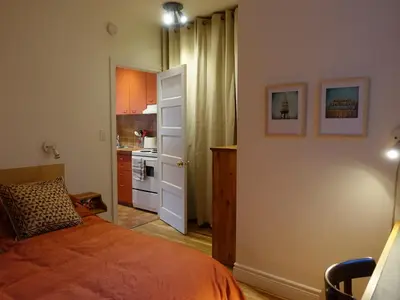 a small bedroom with a bed and a kitchen at Gite à Coté in Montréal