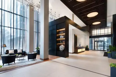 a lobby with a couch and chairs in a building at Hôtel AC Montréal Centre-ville in Montréal
