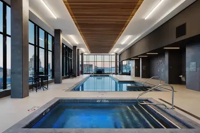 a swimming pool in a building with a table at Hôtel AC Montréal Centre-ville in Montréal