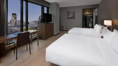 a hotel room with two beds and a desk and a television at Hôtel AC Montréal Centre-ville in Montréal