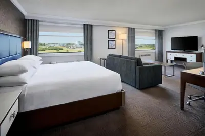 a hotel room with a large bed and a desk at Sheraton Laval Hotel in Laval