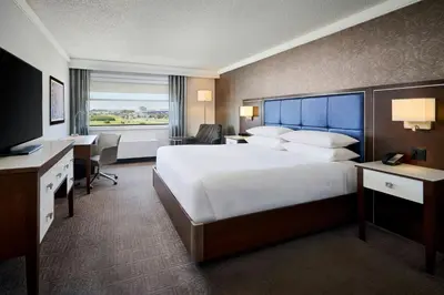 a hotel room with a large bed and a desk at Sheraton Laval Hotel in Laval