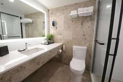 a bathroom with a toilet and a sink and a mirror at Sheraton Laval Hotel in Laval