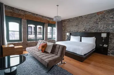 a hotel room with a bed and a couch at Le Petit Hôtel Vieux-Montréal - Saint-Paul by Gray Collection in Montréal