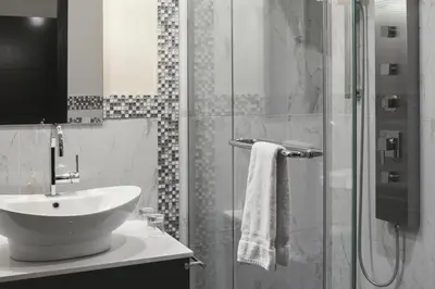 a bathroom with a sink and a glass shower at Le Petit Hôtel Vieux-Montréal - Saint-Paul by Gray Collection in Montréal