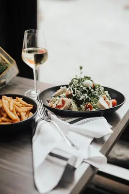 a table with two plates of food and a glass of wine at Le Petit Hôtel Vieux-Montréal - Saint-Paul by Gray Collection in Montréal