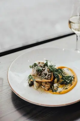a plate of food on a table with a glass of wine at Le Petit Hôtel Vieux-Montréal - Saint-Paul by Gray Collection in Montréal