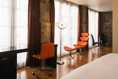 a room with orange chairs and a desk and windows at Le Petit Hôtel Vieux-Montréal - Saint-Paul by Gray Collection in Montréal