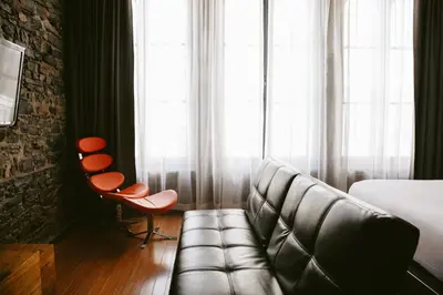 a living room with a couch and a chair at Le Petit Hôtel Vieux-Montréal - Saint-Paul by Gray Collection in Montréal