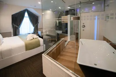 a bathroom with a bed and a shower and a sink at Hôtel Le Rivage in Rosemère