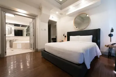 a bedroom with a large bed and a bathroom at Hôtel Le Rivage in Rosemère