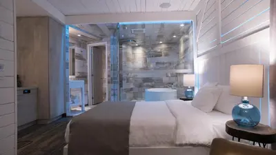 a bedroom with a large bed and a table with a lamp at Hôtel Le Rivage in Rosemère