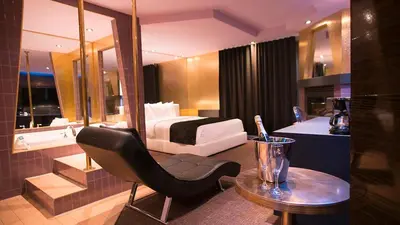 a hotel room with a bed and a chair and a table at Hôtel Le Rivage in Rosemère