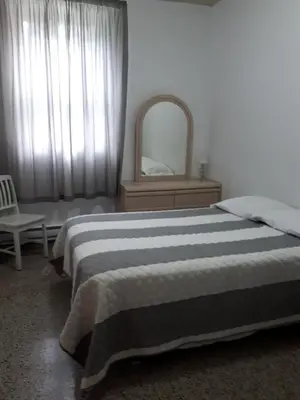 a bedroom with a bed and a mirror and a chair at MHotel Domaine l'Envolée- Maison Fleurie in Victoriaville