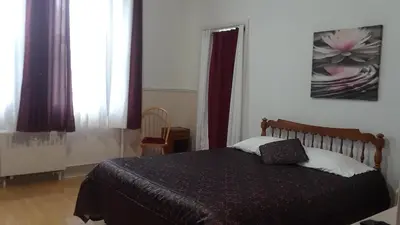 a bedroom with a bed with a black comforter at MHotel Domaine l'Envolée- Maison Fleurie in Victoriaville