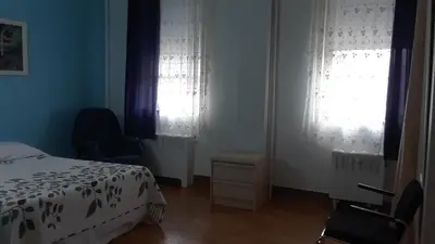 a bedroom with a bed and two windows at MHotel Domaine l'Envolée- Maison Fleurie in Victoriaville