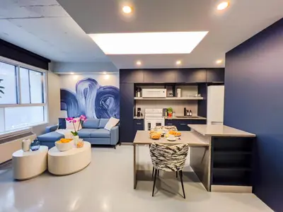 a kitchen and living room with a blue wall at Pierce Boutique Apartments by Simplissimmo in Montréal