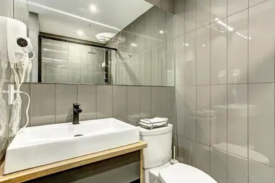 a white bathroom with a sink and a toilet at Pierce Boutique Apartments by Simplissimmo in Montréal