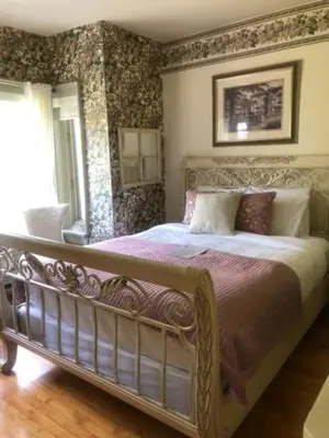 a bedroom with a large bed in a room at La Belle Victorienne in Magog-Orford