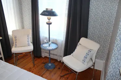 a bedroom with two chairs and a lamp and a bed at La Belle Victorienne in Magog-Orford