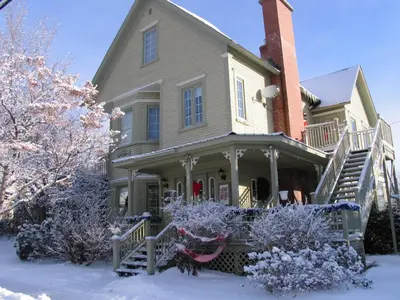 a large house with snow on the ground at La Belle Victorienne in Magog-Orford